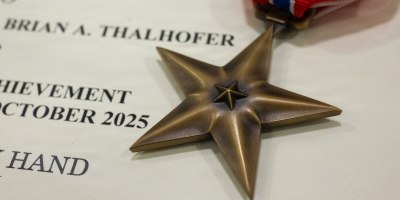 A Bronze Star medal and award citation belonging to U.S. Air Force Lt. Col. Brian Thalhofer, 436th Airlift Wing Safety chief, at Dover Air Force Base, Delaware, April 29, 2026. Thalhofer was one of four Dover AFB Airmen awarded the Bronze Star for their heroic actions while deployed to Al Udeid Air Base, Qatar. (U.S. Air Force photo by Mauricio Campino)