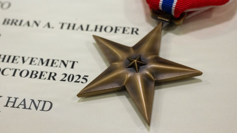 A Bronze Star medal and award citation belonging to U.S. Air Force Lt. Col. Brian Thalhofer, 436th Airlift Wing Safety chief, at Dover Air Force Base, Delaware, April 29, 2026. Thalhofer was one of four Dover AFB Airmen awarded the Bronze Star for their heroic actions while deployed to Al Udeid Air Base, Qatar. (U.S. Air Force photo by Mauricio Campino)