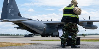 U.S. Air Force aircrew flight equipment specialists, helps assemble a decontamination line while waiting for aircrew to exit an HC-130 Combat King II during Toxic Magnolia, at Moody Air Force Base, Georgia, April 30, 2026. The training emphasized rapid setup and seamless integration with arriving aircraft to maintain mission continuity. (U.S. Air Force photo by Airman 1st Class Noah Noonan)