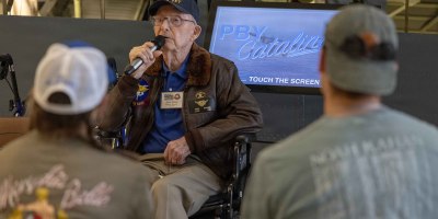 Retired U.S. Navy Lt. Cmdr. Clyde “Cash” Barber speaks to visitors May 5, 2026, at the National Naval Aviation Museum (NNAM) onboard Naval Air Station (NAS) Pensacola. Barber, who has volunteered at the NNAM for the past 12 years, celebrated his 102nd birthday at the museums Cabot Flight Deck. (U.S. Navy photo by Ens. Trent Prince)