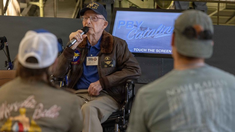 Retired U.S. Navy Lt. Cmdr. Clyde “Cash” Barber speaks to visitors May 5, 2026, at the National Naval Aviation Museum (NNAM) onboard Naval Air Station (NAS) Pensacola. Barber, who has volunteered at the NNAM for the past 12 years, celebrated his 102nd birthday at the museums Cabot Flight Deck. (U.S. Navy photo by Ens. Trent Prince)