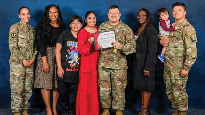 U.S. Army Staff Sgt. Julio Hernandez, center, holds a Volunteer of the Month certificate alongside family members and fellow Soldiers after being recognized as the Anne Arundel County Public Schools’ (AACPS) Volunteer of the Month for May 2026 during a ceremony held on Ft. Meade, Md., May 7, 2026. Staff Sgt. Hernandez has spent over two years volunteering with the community. (Courtesy photo by U.S. Army Staff Sgt. Julio Hernandez and AACPS)