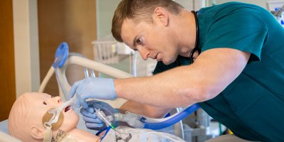 U.S. Navy Lt. j.g. Mathew Rasmussen checks a simulated patient's airway during the final simulation exercise of the inaugural Navy Critical Care Course at Walter Reed National Military Medical Center, Bethesda, Md., May 8, 2026. Walter Reed is the host site for the U.S. Navy's first standardized critical care nursing course, offered across the Defense Health Agency. (DOW photo by Ricardo J. Reyes)