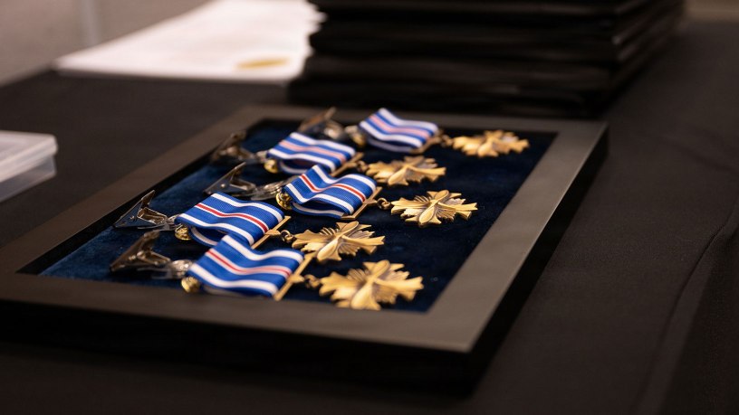 Distinguished Flying Cross medals set on table for presentation during a Distinguished Flying Cross ceremony at RAF Mildenhall, England, May 11, 2026. The award recognizes heroism or extraordinary achievement while participating in aerial flight and honors those whose actions go beyond the demands of duty during combat or active operations against an armed enemy. (U.S. Air Force photo by Airman 1st Class Iris Carpenter)