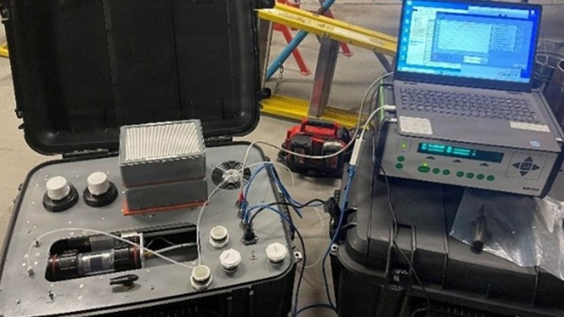 A Residual Life Indicator Sampling Cartridge Analysis System conducts a test on a RLI Satellite Cartridge System cartridge.