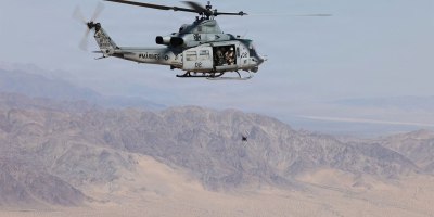 Marines aboard a UH-1Y Venom assigned to Marine Light Attack Helicopter Squadron (HMLA) 169, Marine Aircraft Group 39, 3rd Marine Aircraft Wing, toss a first person view unmanned aircraft system during an integration assessment exercise at Marine Corps Air Ground Combat Center, Twentynine Palms, California, May 13, 2026.