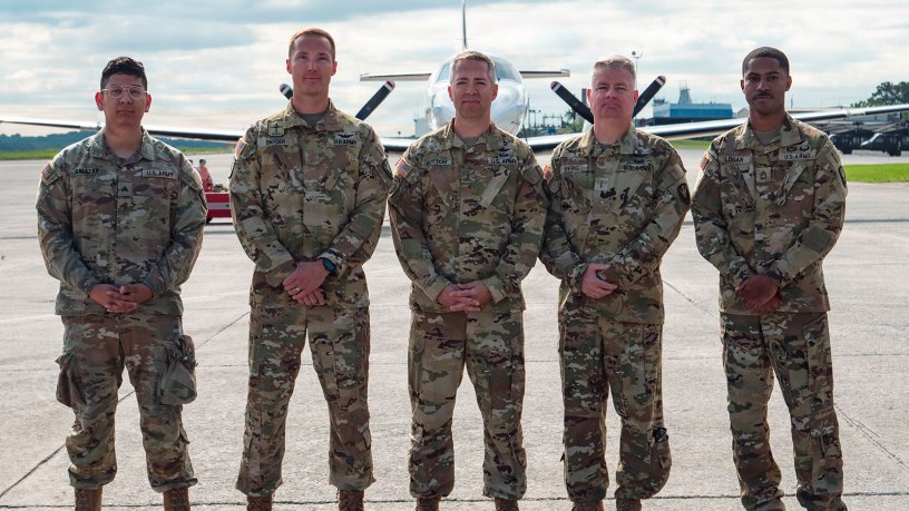 Five deploying members of Bravo Company, 245th Aviation Regiment, Georgia National Guard, stand together in front of a C-26 Metroliner aircraft prior to a takeoff for a deployment, Dobbins Air Reserve Base, Georgia, May 13, 2026. Soldiers from the Georgia Army National Guard departed today for a deployment to Djibouti, where they will provide critical fixed-wing aviation support across the Horn of Africa. (U.S. Air National Guard photo by Staff Sgt. Josiah Meece).