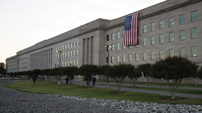 An American flag unfurls down the side of the Pentagon to celebrate Armed Forces Day and honor America's 250th birthday, May 16, 2026. The Betsy Ross flag features 13 white stars in a circle on a blue field with 13 alternating red and white stripes, symbolizing the original colonies.