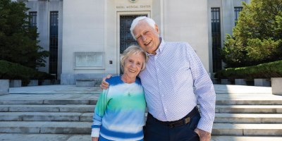 Former U.S. Navy pilot Mike Flannery and his wife, Carol, a former U.S. Navy nurse, pose in front of Walter Reed National Military Medical Center, May 18, 2026, in Bethesda, Maryland. The couple met at the hospital in 1969 when Mike was recovering from injuries sustained aboard the USS Enterprise (CVN-65). (DOW photo by Ricardo J. Reyes)