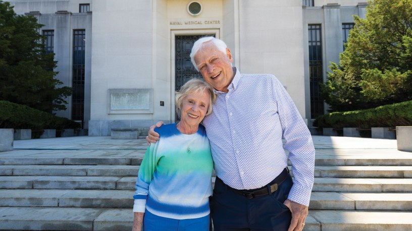 Former U.S. Navy pilot Mike Flannery and his wife, Carol, a former U.S. Navy nurse, pose in front of Walter Reed National Military Medical Center, May 18, 2026, in Bethesda, Maryland. The couple met at the hospital in 1969 when Mike was recovering from injuries sustained aboard the USS Enterprise (CVN-65). (DOW photo by Ricardo J. Reyes)