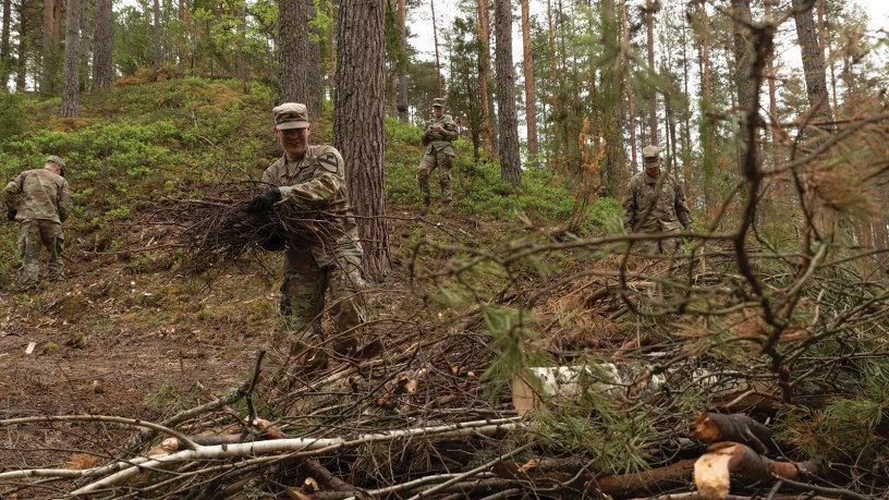 U.S. Army Spc. Ryan Llewellyn, assigned to Charlie Troop, 4th Squadron, 9th Cavalry Regiment, throws debris into a pile as a part of the Estonian Defence Force memorial restoration day at Lounalaagri Lõkkekoht in Võru, Estonia, May 20, 2026.