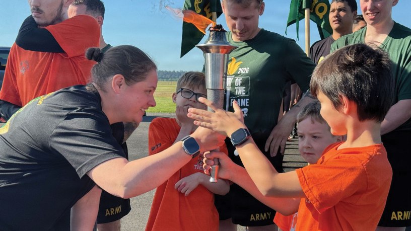 Joint Base Lewis-McChord Provost Marshal Lt. Col. Abby Lanni helps Special Olympics Washington athletes hold the Flame of Hope before starting the 2026 Law Enforcement Torch Run for Special Olympics Washington on May 21 near the Iron Mike statue on JBLM, Lewis Main.