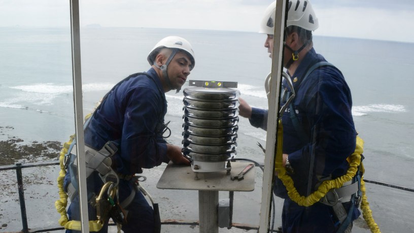 Petty Officer 3rd Class Jason Flores and Petty Officer 1st Class Juan Diaz, members of U.S. Coast Guard Aids to Navigation Team San Diego, verify that the newly installed light-emitting diode beacon is level atop the Point Loma lighthouse in San Diego, Feb. 6, 2013.