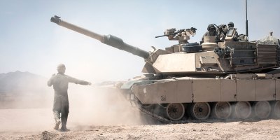 A 1st Battalion, 77th Armored Regiment Soldier ground-guides an M1A2 Abrams Main Battle Tank crew at the Fort Bliss Training Complex in New Mexico, Aug. 28, 2020. Soldiers from 1-77 Armor and the 1st Armored Division have called Fort Bliss home since 2008.