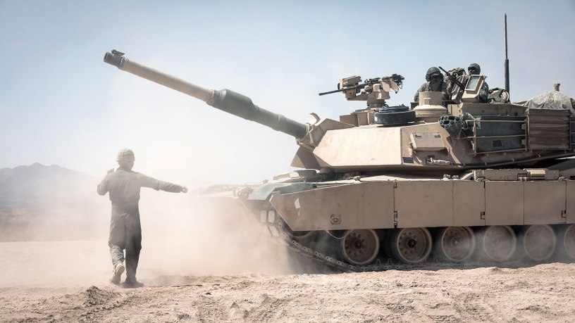 A 1st Battalion, 77th Armored Regiment Soldier ground-guides an M1A2 Abrams Main Battle Tank crew at the Fort Bliss Training Complex in New Mexico, Aug. 28, 2020. Soldiers from 1-77 Armor and the 1st Armored Division have called Fort Bliss home since 2008.