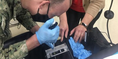 An end user loads a flow cell on a modified field sequencing device during Beholder’s Gaze training, Oct. 24, 2024.