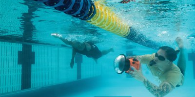 Tech. Sgt. Shawn White, 4th Combat Camera aerial combat camera craftsman, using an underwater housing to capture a new perspective during the swimming event of Warrior Games 2026.
