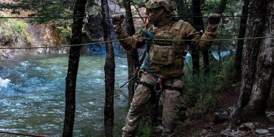A U.S. Airman from the 492nd Special Operations Wing crosses a rope bridge over a river at the Escuela Militar de Montaña in Bariloche, Argentina on March 19, 2026. This training is vital for ensuring that both U.S. and Argentine forces are prepared to meet future security challenges together. (U.S. Air Force photo by Elizabeth Easterling)