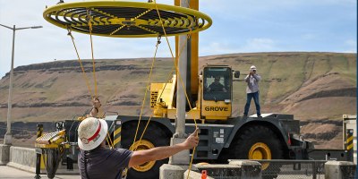 An employee with the USACE Walla Walla District handles the taglines as a crane moves an innovative new bubbler to an awaiting boat. Designed to cool fish ladder water temperatures, this technology encourages species to continue migrating.
