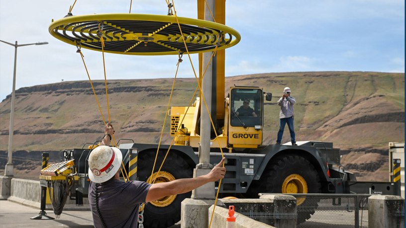An employee with the USACE Walla Walla District handles the taglines as a crane moves an innovative new bubbler to an awaiting boat. Designed to cool fish ladder water temperatures, this technology encourages species to continue migrating.