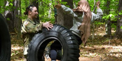 Sgt. Elizabeth Karkos of the Maine National Guard's Counterdrug Task Force helps an Auburn Middle School student navigate a confidence course at the Bog Brook Training Site in Gilead on May 21, 2026.