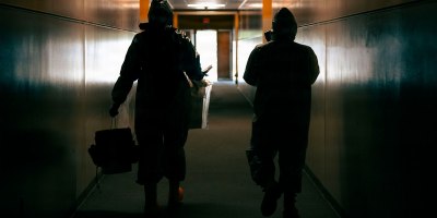 Service members with the 10th Civil Support Team, Washington National Guard, and members of the FBI’s Hazardous Evidence Response Team, exit the contaminated scene after sample collection at Evergreen Elementary School, Joint Base Lewis-McChord, Wash., May 21, 2026.