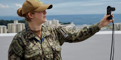 Navy Seaman Sara Clark, assigned to the Naval Oceanography Antisubmarine Warfare Center, Yokosuka, Japan, demonstrates the Kestrel while standing on top of the command's local headquarters building, May 27, 2026.