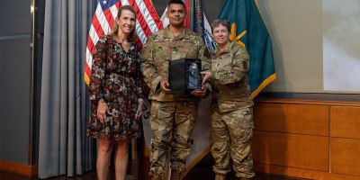 U.S. Army Sgt. Seth Cohen, New Jersey National Guard Recruiting Battalion, center, accepts the Soldier Communicator of the Year award from Sgt. Maj. Mary Ferguson, Sgt. Maj. of Army Public Affairs, right, and Ms. Alayne Conway, Director, Army Communications and Outreach Office, at the 2026 Public Affairs Forum in Alexandria, Virginia, May 29, 2026.