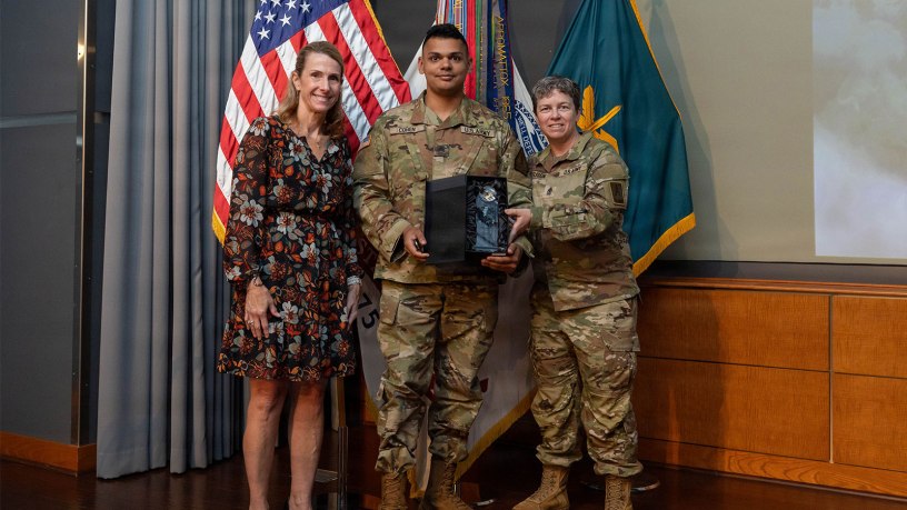 U.S. Army Sgt. Seth Cohen, New Jersey National Guard Recruiting Battalion, center, accepts the Soldier Communicator of the Year award from Sgt. Maj. Mary Ferguson, Sgt. Maj. of Army Public Affairs, right, and Ms. Alayne Conway, Director, Army Communications and Outreach Office, at the 2026 Public Affairs Forum in Alexandria, Virginia, May 29, 2026.