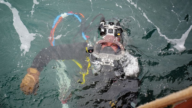 U.S. Navy CM2 Tyler Huntoon, assigned to Construction Dive Detachment 2-4, Underwater Construction Team TWO, returns to the surface following underwater operations in support of P-209, the future Dry Dock 5, at Pearl Harbor Naval Shipyard, Hawaii, June 2, 2026. (U.S. Navy photo by Jhewel Felipe)