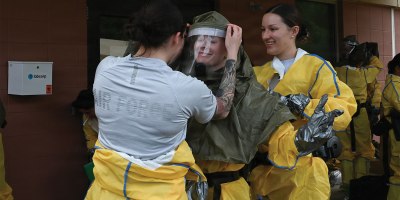 Members from the 103rd Airlift Wing Medical Group help one another to put the hazmat suit on, at Barnes Air National Guard Base, Westfield, Mass., June 2, 2026. The decontamination teams were comprised of 19 members from the medical Air Force Specialty Codes. (U.S. Air National Guard photo by Airman 1st Class Ellen Ozkaptan)