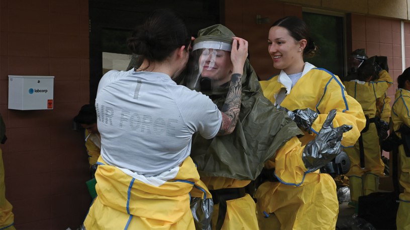 Members from the 103rd Airlift Wing Medical Group help one another to put the hazmat suit on, at Barnes Air National Guard Base, Westfield, Mass., June 2, 2026. The decontamination teams were comprised of 19 members from the medical Air Force Specialty Codes. (U.S. Air National Guard photo by Airman 1st Class Ellen Ozkaptan)