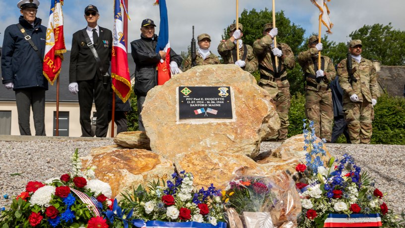 The memorial honoring Pvt. 1st Class Paul E. Duquette is displayed during a commemorative ceremony in Normandy, June 4, 2026. Floral tributes, military colors and presence of Soldiers and community members reflected the lasting gratitude for Duquette’s service during the D-Day Invasion. (U.S. Army photo by Spc. Aysia Hightree)