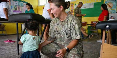 U.S. Army Staff Sgt. Kaitlyn Thomas, Army Forces Medical Detachment physical therapist, plays with a Honduran child at the medical brigade at Escuela Nicolas Montes, Villa de San Antonio, Honduras, June 6, 2026. The medical brigade did more than provide medical care; it brought together people from all walks of life, fostering partnerships and friendships between the United States and Honduras. (U.S. Air Force photo by Staff Sgt. Ethan Sherwood)