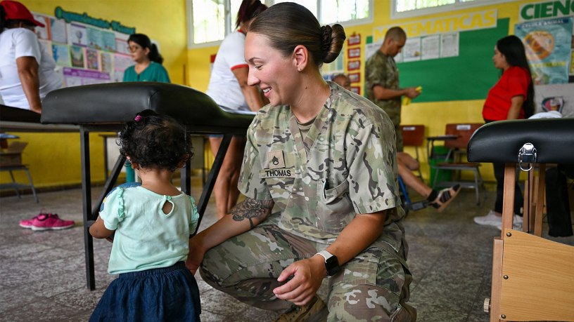 U.S. Army Staff Sgt. Kaitlyn Thomas, Army Forces Medical Detachment physical therapist, plays with a Honduran child at the medical brigade at Escuela Nicolas Montes, Villa de San Antonio, Honduras, June 6, 2026. The medical brigade did more than provide medical care; it brought together people from all walks of life, fostering partnerships and friendships between the United States and Honduras. (U.S. Air Force photo by Staff Sgt. Ethan Sherwood)