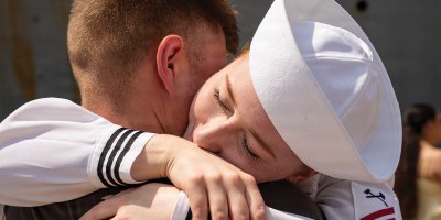 U.S. Navy Damage Controlman Fireman Emma Tripp greets her partner following a 10-month deployment as part of the Iwo Jima Amphibious Ready Group (IWO ARG).