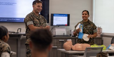 U.S. Marine Corps Capt. Sebastian Tamblyn, left, shelter officer in charge, Marine Corps Air Station New River, and U.S. Navy Petty Officer 1st Class Roxana Q. Lacey, field medical technician, Marine Medium Tiltrotor Squadron 264, Marine Aircraft Group 26, 2nd Marine Aircraft Wing, give a demonstration during a cardiopulmonary resuscitation class at the Marine Corps Medical Home New River at MCAS New River, North Carolina, June 8, 2026.