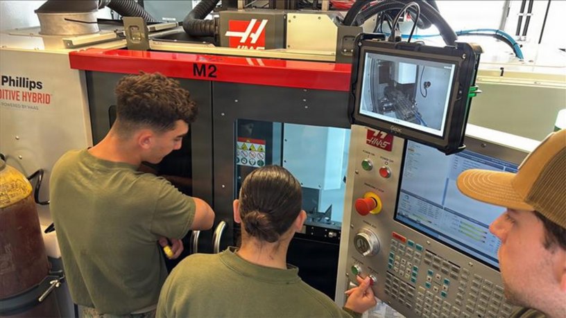 Marines assigned to 1st Maintenance Battalion observe a machining operation on the Advanced Integrated Mobile Machine Shop (AIMMS) hybrid system alongside Naval Surface Warfare Center, Carderock Division engineer Ryan Fisher during new equipment training (NET) on May 4, 2026.