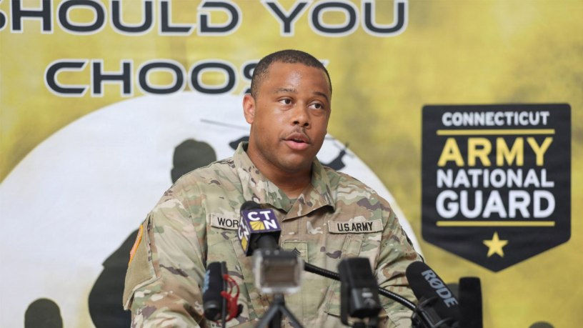 U.S. Army Sgt. Sinclair Worrell Oliver, a soldier assigned to the 130th Public Affairs Detachment, introduces Maj. Michael Wilcoxson, the Connecticut National Guard's state public affairs officer roleplaying as the state's adjutant general, during a mock press conference during Yankee Thunder, a crisis communication exercise at the Gov. William A. O'Neill Armory in Hartford, Conn. June 11, 2026.