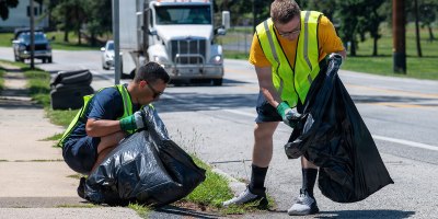 Lt. j.g. Christopher San Miguel and Lt. Jacob Butikofer, project officers assigned to Naval Supply Systems Command (NAVSUP) Business Systems Center (BSC) onboard Naval Support Activity Mechanicsburg, remove trash and debris from a two-mile stretch of Sporting Hill Road as part of the Pennsylvania Department of Transportation (PennDOT) state-wide Adopt A Highway program, June 16.