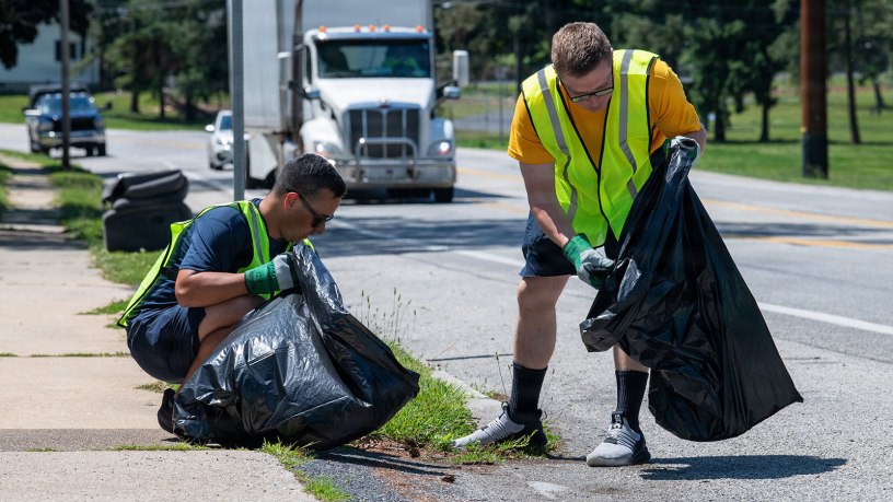 Lt. j.g. Christopher San Miguel and Lt. Jacob Butikofer, project officers assigned to Naval Supply Systems Command (NAVSUP) Business Systems Center (BSC) onboard Naval Support Activity Mechanicsburg, remove trash and debris from a two-mile stretch of Sporting Hill Road as part of the Pennsylvania Department of Transportation (PennDOT) state-wide Adopt A Highway program, June 16.