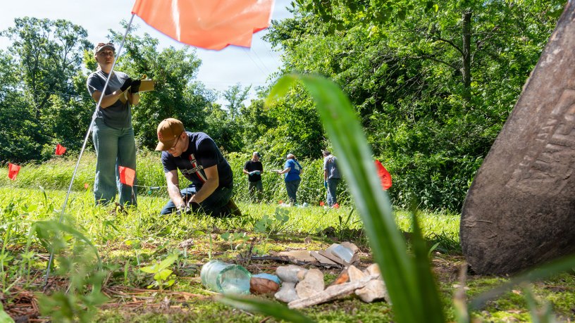 Fort Leonard Wood Directorate of Public Works Environmental Division employees, Elizabeth Woods (left), Natural Resources technician; and Andrew Phillips, archeologist, process a mock cultural resources crime scene June 17, 2026, behind Countee Hall.