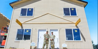 Wyoming Army National Guard 1st Lt. Everhett Biland, commander of the 307th Engineer Utilities Detachment, and the detachment’s senior enlisted leader, Sgt. 1st Class Tyler Cunningham, pose for a photo in front of a home during a conclusion ceremony for a Habitat for Humanity homebuilding project in Cheyenne, Wyoming, June 26, 2026.