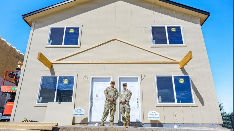 Wyoming Army National Guard 1st Lt. Everhett Biland, commander of the 307th Engineer Utilities Detachment, and the detachment’s senior enlisted leader, Sgt. 1st Class Tyler Cunningham, pose for a photo in front of a home during a conclusion ceremony for a Habitat for Humanity homebuilding project in Cheyenne, Wyoming, June 26, 2026.