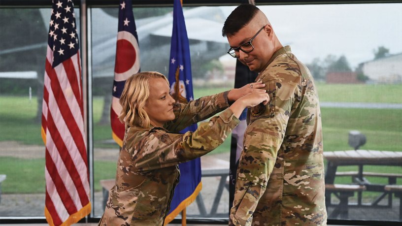 U.S. Air Force Lt. Col. Britney Hensley, commander of the 126th Intelligence Squadron, removes the 126th IS unit patch from Tech. Sgt. Dylan Jacques, an intelligence analyst assigned to the 126th IS at Springfield-Beckley Air National Guard Base, who transferred to the 76th Intelligence, Surveillance and Reconnaissance Squadron in a historic ceremony June 26, 2026.