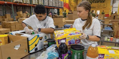 Midshipman 3rd Class Cesar Lopez, left, from Las Vegas, and Midshipman 3rd Class Claudia Maron, from Madison, Mississippi, sort donated food at the Maryland Food Bank in Halethorpe, Maryland, June 27, 2026.