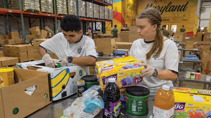 Midshipman 3rd Class Cesar Lopez, left, from Las Vegas, and Midshipman 3rd Class Claudia Maron, from Madison, Mississippi, sort donated food at the Maryland Food Bank in Halethorpe, Maryland, June 27, 2026.