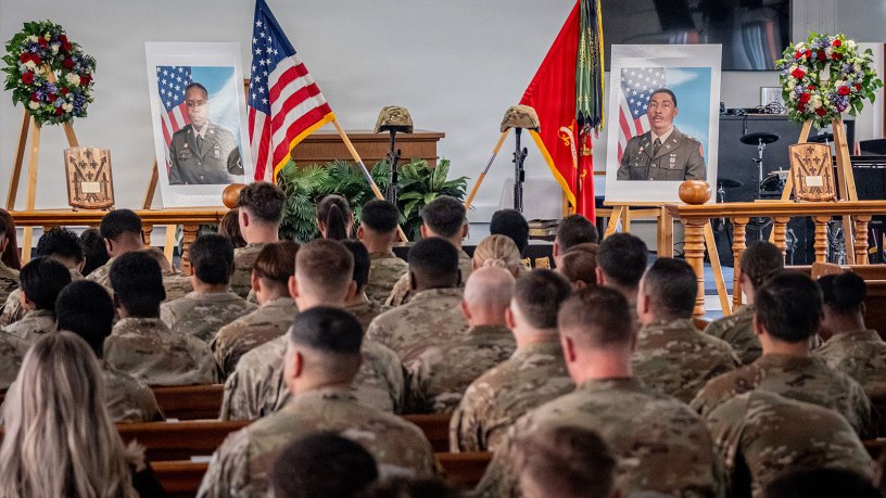 A memorial display featuring battlefield crosses, portraits, personal effects and wreaths honoring U.S. Army 1st Lt. Kendrick Key and U.S. Army Spc. Mariyah Collington, who served with 5th Battalion, 4th Air Defense Artillery Regiment, 52D Air Defense Artillery Brigade, 10th Army Air & Missile Defense Command, stands inside Katterbach Chapel as soldiers and attendees gather for a memorial ceremony at Katterbach Kaserne, Germany, June 29, 2026.
