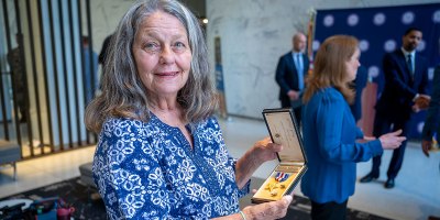 Claire Murphy, niece of Silver Star recipient Edmund Dobek, holds up her uncle's medal following a ceremony at the State Office Building in Hartford, Conn. June 30, 2026.
