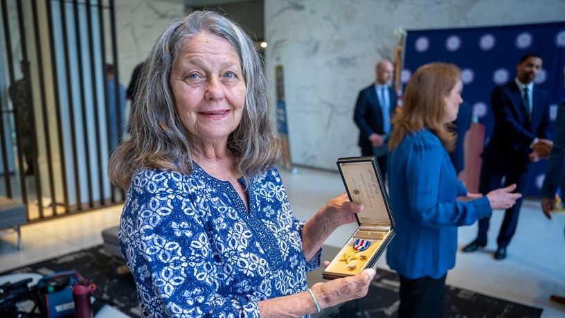 Claire Murphy, niece of Silver Star recipient Edmund Dobek, holds up her uncle's medal following a ceremony at the State Office Building in Hartford, Conn. June 30, 2026.